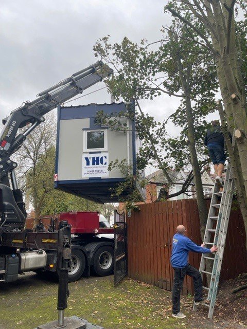 Portable cabin being installed on site by crane.